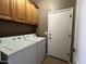 Laundry room with cabinets and appliances. Door to the right at 11946 W Jackson St, Avondale, AZ 85323