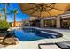 Backyard pool with rock waterfall and tanning ledge surrounded by well manicured desert landscaping at 1202 E Milada Dr, Phoenix, AZ 85042