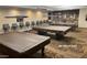 Billiards room featuring multiple tables with plush, brown covers and seating for players at 12215 S Potomac St, Phoenix, AZ 85044