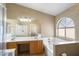 Bathroom with a double sink vanity and a tub with a window at 1301 N Jackson St, Chandler, AZ 85225