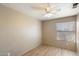 Bright bedroom featuring light wood floors, a ceiling fan, and a window with blinds at 1301 N Jackson St, Chandler, AZ 85225