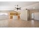 Spacious open-concept living room showcasing tile flooring, a ceiling fan, and access to the kitchen and front entrance at 1301 N Jackson St, Chandler, AZ 85225