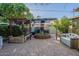 Serene backyard featuring lush greenery, paved seating area, and cozy pergola at 1335 E Oregon Ave, Phoenix, AZ 85014