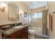 Well-lit bathroom featuring a vanity with a dark countertop and a shower-tub combination at 1335 E Oregon Ave, Phoenix, AZ 85014