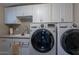 Functional laundry room with a modern washer and dryer, ample cabinet space and sink at 1335 E Oregon Ave, Phoenix, AZ 85014