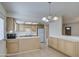 Cozy kitchen with tile floors, light wood cabinets, a peninsula, and white appliances at 1340 N Oregon St, Chandler, AZ 85225