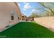 A spacious backyard features a patch of artificial turf and a brick-paver patio at 13624 W Desert Moon Way, Peoria, AZ 85383