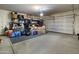 Spacious garage with ample storage shelves, a roll-up door, and a clean, organized layout at 13624 W Desert Moon Way, Peoria, AZ 85383