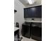 Modern laundry room features black front-loading washer and dryer and matching cabinetry at 13624 W Desert Moon Way, Peoria, AZ 85383