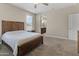 Comfortable bedroom with plush carpet, wooden furniture, and a view into the well-lit ensuite bathroom at 13624 W Desert Moon Way, Peoria, AZ 85383