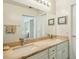 Bathroom with double sink vanity, large mirror, and neutral color scheme at 14432 W Yukon Dr, Sun City West, AZ 85375