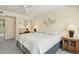 Bedroom featuring a fan, mirrored closet doors, and matching lamps on both sides of bed at 14432 W Yukon Dr, Sun City West, AZ 85375