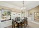 Formal dining room with large windows, neutral decor, and a classic chandelier at 14432 W Yukon Dr, Sun City West, AZ 85375