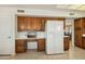 Kitchen with wooden cabinets, a built-in desk, and a modern refrigerator, creating a functional and stylish workspace at 14432 W Yukon Dr, Sun City West, AZ 85375