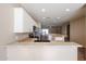 Well-lit kitchen featuring white cabinetry, stainless steel appliances, and a breakfast bar at 14616 W Ventura St, Surprise, AZ 85379