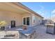 Relaxing covered patio with a fire pit, outdoor grill, and sliding glass doors to the interior at 151 N 116Th Dr, Avondale, AZ 85323