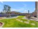 Lush backyard featuring a sparkling pool with rock waterfall, mature trees, and grassy entertaining area at 151 N 116Th Dr, Avondale, AZ 85323