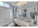 Bathroom with a granite vanity, tiled shower, and a decorative curtain at 151 N 116Th Dr, Avondale, AZ 85323