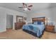 Bedroom featuring a ceiling fan, carpet flooring, and a wooden dresser with mirror at 151 N 116Th Dr, Avondale, AZ 85323