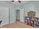 Cozy bedroom featuring neutral walls, carpet, closet, and built-in bookcase filled with books and collectibles at 151 N 116Th Dr, Avondale, AZ 85323