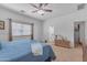 Comfortable bedroom featuring a ceiling fan, soft carpet, and large window for natural light at 151 N 116Th Dr, Avondale, AZ 85323