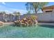 The pool has beautiful rock waterfall feature and is surrounded by lush greenery at 151 N 116Th Dr, Avondale, AZ 85323