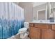 Well-lit bathroom features a vanity and a shower with blue decorative curtain at 16102 W Miami St, Goodyear, AZ 85338