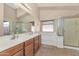 Bathroom featuring double sinks, large mirror, shower, and a bathtub at 16102 W Miami St, Goodyear, AZ 85338