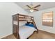 Cozy bedroom featuring a wooden bunk bed, ceiling fan, and a window for natural light at 16102 W Miami St, Goodyear, AZ 85338