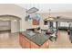 Open kitchen features a granite island, hanging pot rack and stainless steel appliances at 16102 W Miami St, Goodyear, AZ 85338