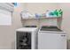 Well-equipped laundry room with modern washer and dryer, and shelving for storage at 16102 W Miami St, Goodyear, AZ 85338