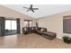 Living room with a ceiling fan, tile floors, and a sliding glass door at 16102 W Miami St, Goodyear, AZ 85338