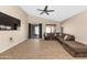 Vaulted living room with ceiling fan, tile floors, and sliding glass door at 16102 W Miami St, Goodyear, AZ 85338