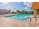 Community swimming pool with bright blue skies, sun deck lounge seating, and mature landscape at 1612 Leisure World --, Mesa, AZ 85206