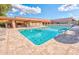 Community swimming pool features sun deck lounge seating, shade umbrellas and covered seating area at 1612 Leisure World --, Mesa, AZ 85206