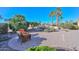 Expansive backyard featuring palm trees, a rock waterfall, and a cozy seating area for relaxation and enjoyment at 16409 W Alvarado Dr, Goodyear, AZ 85395