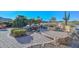 Backyard with custom pavers, a fire pit and seating, and lush desert landscaping at 16409 W Alvarado Dr, Goodyear, AZ 85395