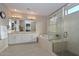 Expansive bathroom with dual sinks, soaking tub, glass shower enclosure and bright lighting at 16409 W Alvarado Dr, Goodyear, AZ 85395