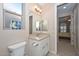 Bathroom with beige stone countertops, white cabinets and view into connecting room at 16409 W Alvarado Dr, Goodyear, AZ 85395