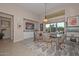 Elegant dining room with modern light fixture and views of the backyard scenery at 16409 W Alvarado Dr, Goodyear, AZ 85395