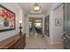 Inviting foyer featuring a console table, striking artwork, and a view into a well-lit living space at 16409 W Alvarado Dr, Goodyear, AZ 85395