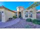 Stunning home entrance with a circular tower, arched windows, and desert landscaping at 16409 W Alvarado Dr, Goodyear, AZ 85395