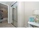 Hallway featuring mirrored closet doors, an open bathroom view, and a small accent table with a lamp at 16409 W Alvarado Dr, Goodyear, AZ 85395