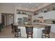 A spacious island is the focal point of this open concept kitchen with white cabinets and granite countertops at 16409 W Alvarado Dr, Goodyear, AZ 85395