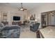 Comfortable living room features neutral tones, a ceiling fan, and large windows at 16409 W Alvarado Dr, Goodyear, AZ 85395