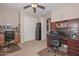 Spacious office area with two desks, a ceiling fan, and organized shelving units for a productive workspace at 16409 W Alvarado Dr, Goodyear, AZ 85395