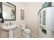 Cozy powder room with modern fixtures, pedestal sink and decorative art at 16409 W Alvarado Dr, Goodyear, AZ 85395