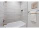 Modern bathroom with a white bathtub, gray tiled walls, and bronze fixtures at 1642 E Monte Vista Rd # 9, Phoenix, AZ 85006