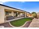 A covered patio with a hot tub, dining set, and a grassy area, perfect for outdoor entertaining at 17138 W Las Palmaritas Dr, Waddell, AZ 85355