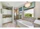 Stylish bathroom featuring a soaking tub, a chandelier, tiled accents, and a separate glass shower at 17138 W Las Palmaritas Dr, Waddell, AZ 85355